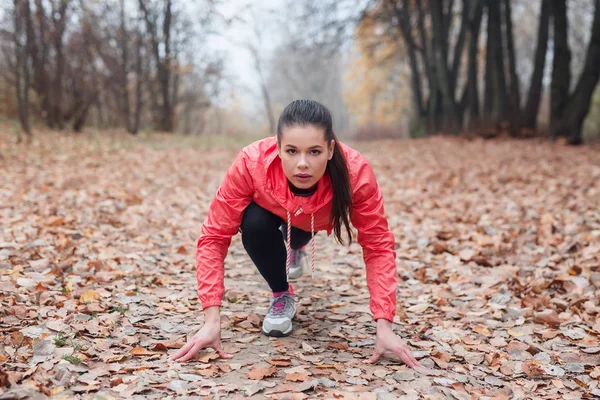 Sonbahar parkında spor yapan kadın antrenmanı ve koşu. Başlamaya hazır. — Stok fotoğraf