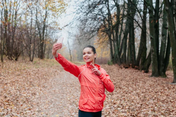 Fitnessfrau trainiert draußen und macht Selfie im Park. — Stockfoto