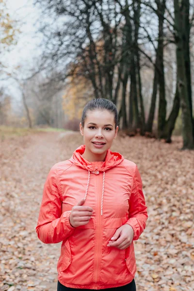 Läuferin junge Frau joggt im Herbstwald. — Stockfoto