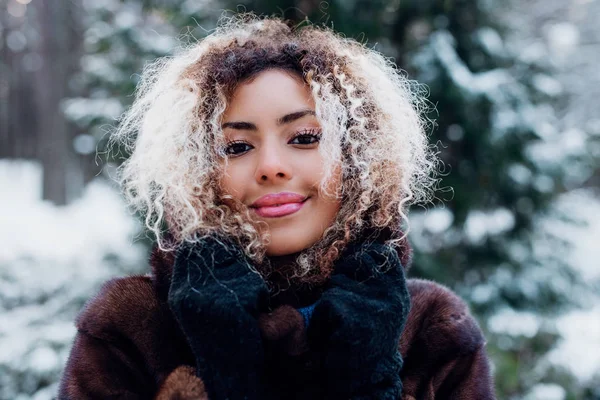 Hermosa sonriente joven africana en invierno al aire libre. Concepto de invierno — Foto de Stock