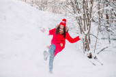 Dívka si hraje se sněhem v zimě parku