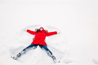 Karda bir kadın tarafından yapılmış bir kar meleği. Üst düz genel görünüm