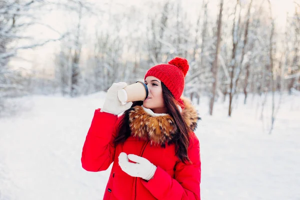 Retrato de joven hermosa mujer en ropa roja beber café en invierno fondo al aire libre —  Fotos de Stock