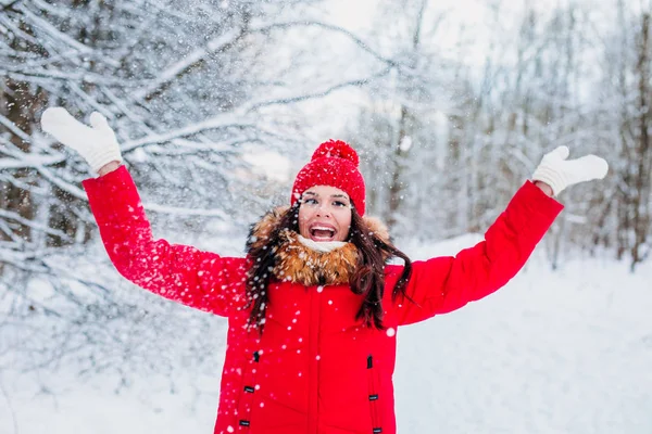 Mujer joven lanzando nieve en el aire en el soleado día de invierno —  Fotos de Stock