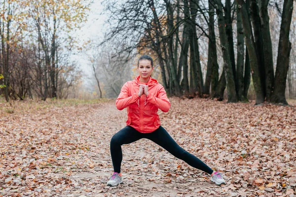 Esneme ve egzersiz. Genç sporcu kız sonbahar parkında spor yapıyor. . — Stok fotoğraf