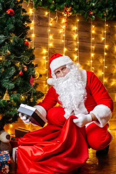 Jultomten nära julgran med gåvor. Juletid — Stockfoto