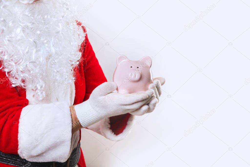 piggy bank in hands of Santa Claus on a white background