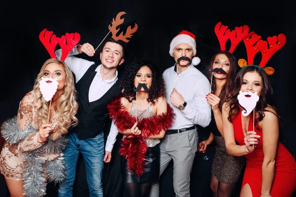 Seis jovens amigos engraçados comemorando o Natal. Grupo de amigos no clube se divertindo. Festa de anos novos — Fotografia de Stock