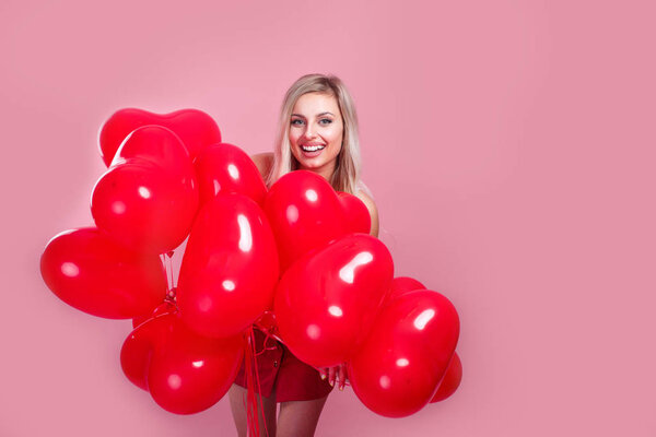 Beauty girl with red hearts air balloons laughing on pink background, Valentines Day