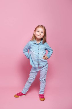 Cute little girl in blue clothes smiling on camera
