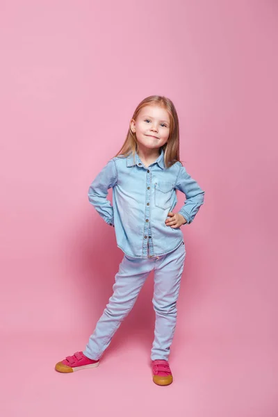 Linda niña en ropa azul sonriendo en la cámara — Foto de Stock