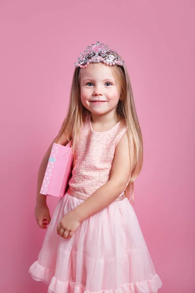 Πορτρέτο του χαριτωμένο χαμογελαστό κοριτσάκι με κουτί δώρου σε φόρεμα πριγκίπισσα και στέμμα — Φωτογραφία Αρχείου