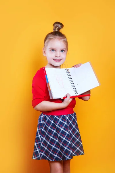 Smiling little student girl with notebook. Education and school concept .