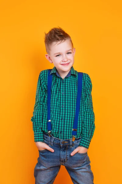 Beautiful smiling caucasian boy in a green shirt on yellow background. — ストック写真