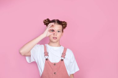 Beyaz tişörtlü sevimli kızın portresi pembe arka planda iyi bir sembol oluşturuyor.
