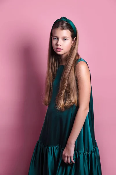 Moda menina bonita em vestido de cetim esmeralda com cabelo comprido posando em estúdio . — Fotografia de Stock