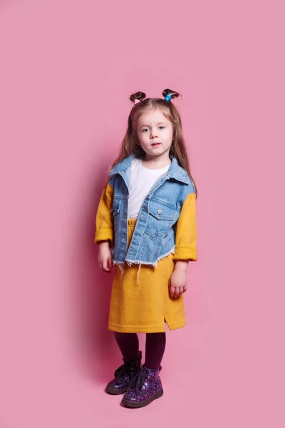 Modelo niña en ropa de moda sobre fondo rosa — Foto de Stock