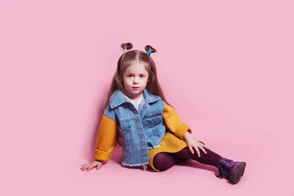 Κομψό κοριτσάκι 4-5 ετών που φοράει denim ρούχα σε ροζ φόντο — Φωτογραφία Αρχείου