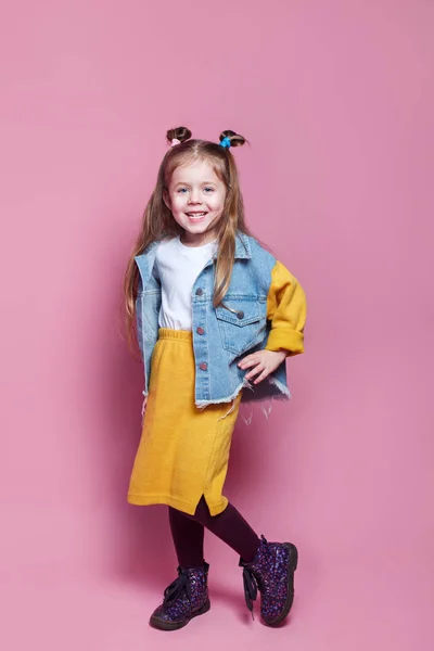 Retrato de longitud completa de niña linda en ropa vaqueros elegantes mirando a la cámara y sonriendo — Foto de Stock