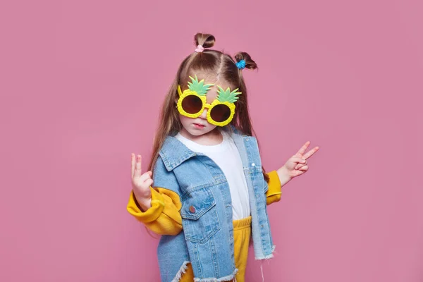 Concetto moda estate. allegra bambina in grandi occhiali da sole ananas su sfondo rosa — Foto Stock