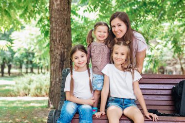 Anne ve kızları parkta dinleniyorlar. Aile zamanı.