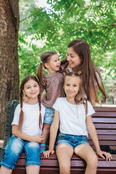 Estilo de vida retrato mamá y tres hijas en happines en el exterior en el parque — Foto de Stock