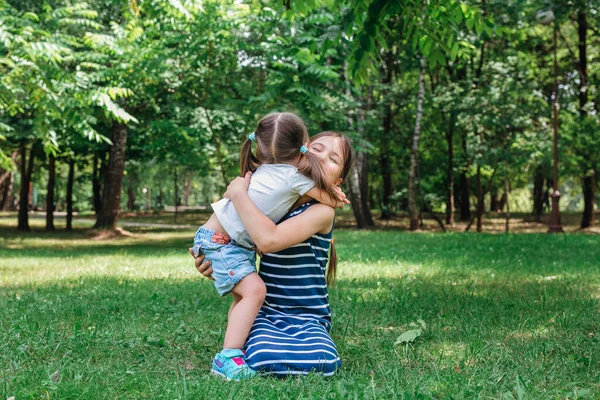 Dos niños felices jugando en la hierba verde al aire libre en el parque de verano — Foto de Stock