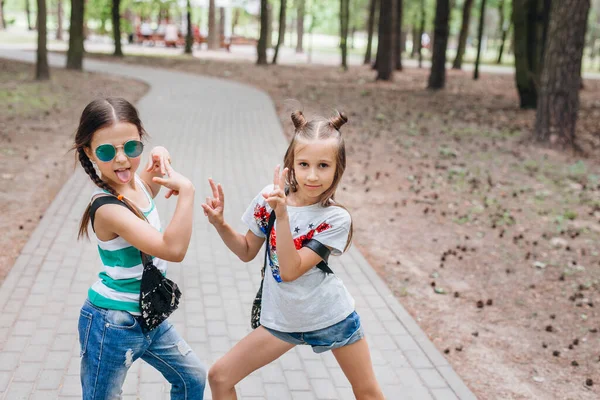 Dwa stylowe dziewczynki w okularach przeciwsłonecznych zabawy na świeżym powietrzu — Zdjęcie stockowe