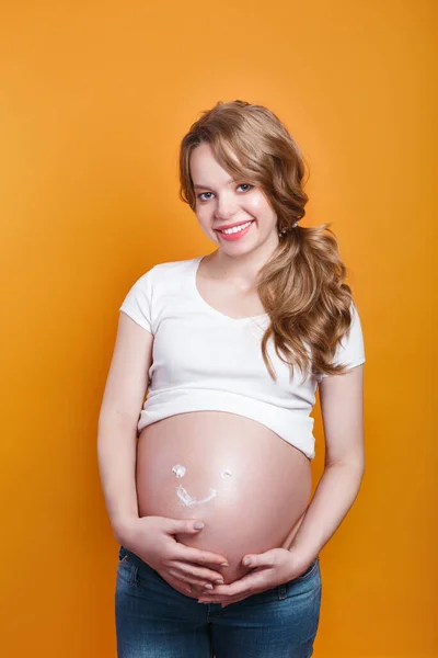 Gravid kvinna med leende från fuktgivande kräm för bristningar — Stockfoto