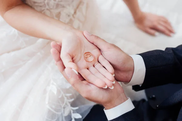 Närbild av brudgummar hand och brudar hand håller vigselringar — Stockfoto