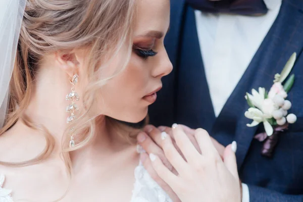 Close-up van een mooi bruidspaar in het park. Ze kussen en knuffelen elkaar. — Stockfoto