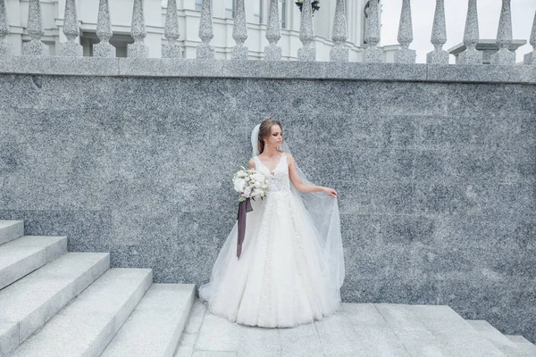 La hermosa mujer posando en un vestido de novia al aire libre — Foto de Stock