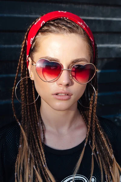 Retrato de moda de mujer hipster joven con bandana y gafas de sol. Peinado pequeñas trenzas — Foto de Stock