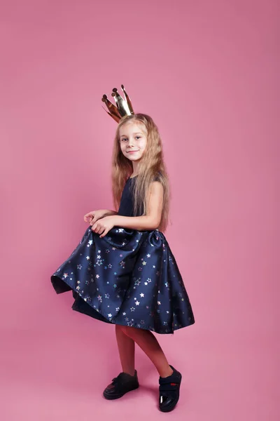 Ευτυχισμένος εορτασμός του πάρτι γενεθλίων. κοριτσάκι με φόρεμα πριγκίπισσα και στέμμα σε ροζ φόντο — Φωτογραφία Αρχείου