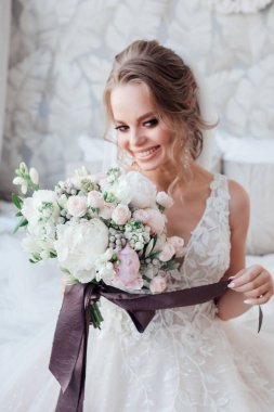 Gülümseyen gelin odada düğün buketiyle