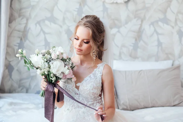 Krásná nevěsta se svatební kytice, atraktivní žena ve svatebních šatech v interiéru. — Stock fotografie