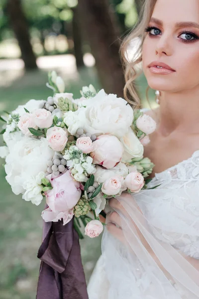 Novia con ramo de flores en el parque de verano — Foto de Stock