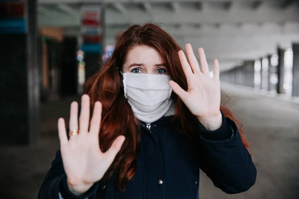 Stoppa viruset och epidemiska sjukdomar. Rädd kvinna i medicinsk skyddsmask visar gest stopp i staden. — Stockfoto