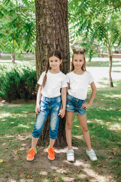 Dos niñas con camisetas blancas de pie en el parque al aire libre. Prepárate. . — Foto de Stock