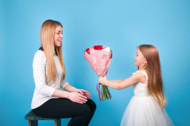 Küçük kız annesini tebrik eder ve bir buket gül verir..