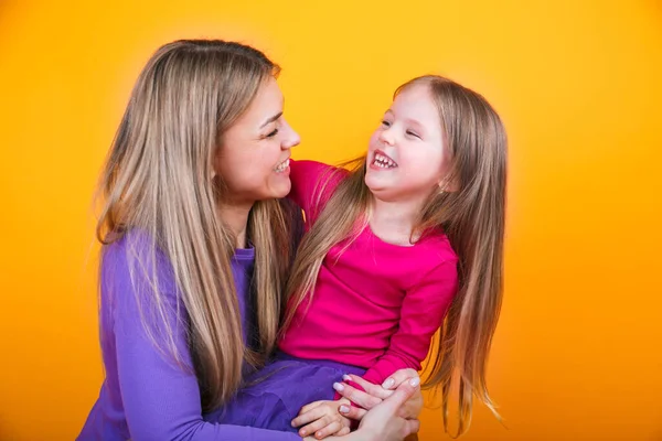 Happy Beautiful Mother Daughter Sitting Together Having Fun Yellow Studio — Stock Photo, Image