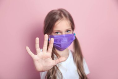 Yüz maskeli çocuk portresi Corona virüsünü durdurmak için el hareketi gösteriyor. Küresel koronavirüs salgını kavramı