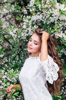 Bahar bahçesinde uzun saçlı, güzel doğal bir kadın.