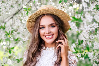 Güzel, mutlu, esmer kadın ılık bir bahar gününde çiçek parkında.