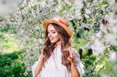 Genç ve güzel bir kadın çiçek açan bahçeye bakıyor..