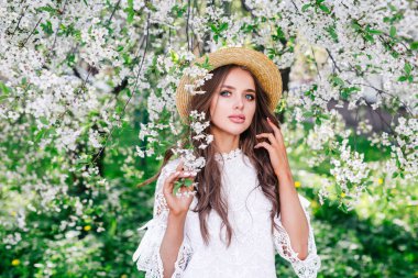 Çiçek parkında dinlenen şehvetli, güzel genç bir kadın..