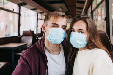 Koruyucu maskeli genç çift kendilerini karantinada tutuyorlar..