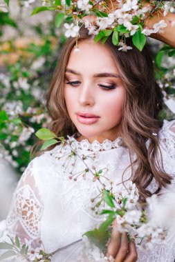 Çiçekli bir baharda kokunun tadını çıkaran güzel genç bir kadın.