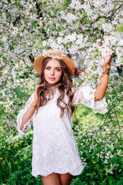 Όμορφη Νεαρή Κοπέλα Ψάθινο Καπέλο Στέκεται Ανάμεσα Στα Ανθισμένα Δέντρα — Φωτογραφία Αρχείου