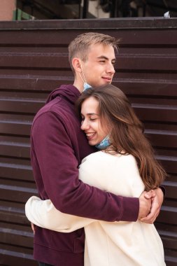 Şehirdeki virüslerden korunmak için maske takan çift birbirine veda ediyor.